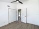 Bedroom with wood-look flooring, white walls, ceiling fan, and double closet doors at 1209 W Camellia Dr, Brandon, FL 33510