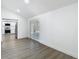 Bright living room with wood-look flooring, white walls, kitchen access, and glass doors at 1209 W Camellia Dr, Brandon, FL 33510