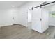 Bright room featuring neutral-colored flooring, fresh paint, and decorative barn door at 1209 W Camellia Dr, Brandon, FL 33510