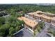 Aerial view of the multi Gathering structure with parking lots, lush tree coverage, and waterway to the east at 12760 Indian Rocks Rd # 579, Largo, FL 33774