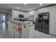 Modern kitchen featuring white cabinets, granite countertops, stainless steel appliances, and bar stool seating at 12760 Indian Rocks Rd # 579, Largo, FL 33774