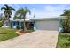 Charming blue single-story home with well-manicured lawn, mature landscaping, and a two-car garage at 13979 Barbados Dr, Seminole, FL 33776