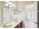 Bathroom featuring dual sinks, vanity lighting, marble counter tops and a connecting door to bedroom at 16113 Ternglade Dr, Lithia, FL 33547