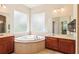Relaxing bathroom featuring a jacuzzi tub, dual vanities, and ample natural light at 16113 Ternglade Dr, Lithia, FL 33547
