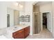 Well-lit bathroom with a spacious vanity, walk-in shower, and easy access to a walk-in closet at 16113 Ternglade Dr, Lithia, FL 33547