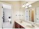 Bathroom featuring dual sinks, vanity lighting, marble counter tops and a connecting door to bedroom at 16113 Ternglade Dr, Lithia, FL 33547