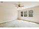 Bright bedroom featuring plush carpet and abundant natural light from three windows creating a serene retreat at 16113 Ternglade Dr, Lithia, FL 33547