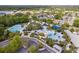 Aerial view of community pool area with multiple pools, splash pad, lounging areas, and lush greenery at 16113 Ternglade Dr, Lithia, FL 33547