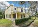 Side view of a two-story yellow home showcasing its architectural design and well-maintained landscaping at 16113 Ternglade Dr, Lithia, FL 33547