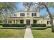 Charming yellow two-story home with a covered front porch, columns, and well-manicured landscaping at 16113 Ternglade Dr, Lithia, FL 33547