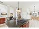 Open-concept kitchen featuring a granite island with cooktop, and seamless flow to living and dining areas at 16113 Ternglade Dr, Lithia, FL 33547
