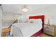 Cozy bedroom with red accent wall, modern lighting, and view to the stairwell at 1617 Oak Ne St, St Petersburg, FL 33704