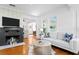 Open-concept living room with a brick fireplace, hardwood floors, and bright natural light at 1617 Oak Ne St, St Petersburg, FL 33704