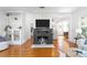 Cozy living room featuring a brick fireplace, built-in shelving, and hardwood floors at 1617 Oak Ne St, St Petersburg, FL 33704
