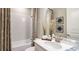 Bright bathroom with white tiled walls, a bathtub with shower, and a large mirror above the sink at 1797 Trailhead Ln, Zephyrhills, FL 33541