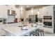 Modern kitchen boasts white cabinetry, stainless steel appliances, and a large island with seating, perfect for entertaining at 1797 Trailhead Ln, Zephyrhills, FL 33541