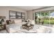 Stylish living room features a comfortable sectional sofa, decorative rug, and sliding glass doors to the outdoor patio at 1797 Trailhead Ln, Zephyrhills, FL 33541