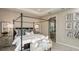Serene main bedroom with a tray ceiling, natural light, and an en-suite bathroom at 1797 Trailhead Ln, Zephyrhills, FL 33541