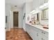 Bright bathroom featuring double vanity with marble countertops, decorative mirrors and lovely marble flooring at 18502 Keystone Manor Rd, Odessa, FL 33556