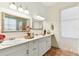 Bright bathroom featuring double vanity with marble countertops, decorative mirrors and marble flooring at 18502 Keystone Manor Rd, Odessa, FL 33556