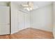 Bright bedroom features hardwood floors, a ceiling fan, and double door closet at 18502 Keystone Manor Rd, Odessa, FL 33556
