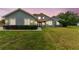 Charming home featuring a well-manicured lawn, lush shrubbery and a red tile roof at 18502 Keystone Manor Rd, Odessa, FL 33556