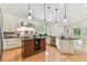 Stylish kitchen with an island, stainless steel appliances, black countertops, and hardwood floors at 18502 Keystone Manor Rd, Odessa, FL 33556