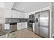 Updated kitchen features stainless steel appliances, granite countertops, and white cabinets at 223 Island Way # 2C, Clearwater Beach, FL 33767