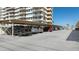 Covered parking area with multiple vehicles parked underneath at residential building on a sunny day at 223 Island Way # 2C, Clearwater Beach, FL 33767