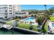 Community pool area with lounge chairs, tables, and waterfront access with boat docks at 223 Island Way # 2C, Clearwater Beach, FL 33767