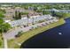 This aerial view captures a pond-side condo community with palm trees, ample parking, and scenic surroundings at 2291 Americus W Blvd # 23, Clearwater, FL 33763