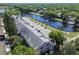 Aerial view of a pink complex shows its proximity to a tranquil pond, lush greenery, and convenient parking at 2291 Americus W Blvd # 23, Clearwater, FL 33763