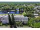An aerial view showcases a well-kept condo community near a scenic pond with lush greenery at 2291 Americus W Blvd # 23, Clearwater, FL 33763