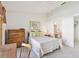 Cozy bedroom with white walls, a ceiling fan and a floral bedspread and adjoining bathroom at 2291 Americus W Blvd # 23, Clearwater, FL 33763