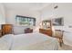 Traditional bedroom with dresser, mirror, and soft natural light from the window at 2291 Americus W Blvd # 23, Clearwater, FL 33763