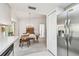 View of the dining area from the kitchen, featuring a chandelier, hutch, and stainless steel fridge at 2291 Americus W Blvd # 23, Clearwater, FL 33763