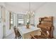 Cozy dining room featuring a charming chandelier, hutch, and bay window with natural light at 2291 Americus W Blvd # 23, Clearwater, FL 33763
