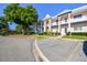 Low angle view of a multi-Gathering, two story building with white paint, multiple balconies and parking on the left at 2291 Americus W Blvd # 23, Clearwater, FL 33763