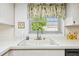 Close-up of kitchen sink with stylish faucet and window view, showcasing clean countertops at 2291 Americus W Blvd # 23, Clearwater, FL 33763