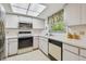 Well-lit kitchen featuring white cabinets, modern appliances, and a sunny window at 2291 Americus W Blvd # 23, Clearwater, FL 33763