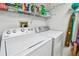The laundry room is equipped with a washing machine, dryer, and wire shelving for storage at 2291 Americus W Blvd # 23, Clearwater, FL 33763