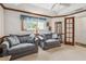 Bright sitting area with large sofas, tray ceilings, and view of bathroom at 2291 Americus W Blvd # 23, Clearwater, FL 33763