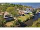 Scenic aerial view of a waterfront home with a lush lawn and mature trees, offering a tranquil setting at 3334 Pineview Dr, Holiday, FL 34691