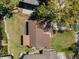 Aerial view of a home with a well-maintained roof and spacious lawn surrounded by trees and a waterfront canal at 3334 Pineview Dr, Holiday, FL 34691