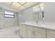 Bright bathroom featuring a shower-tub, a large mirror, and vanity storage at 3334 Pineview Dr, Holiday, FL 34691