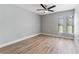 Light-filled bedroom features three windows, neutral paint, and wood-look floors at 3334 Pineview Dr, Holiday, FL 34691
