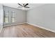 Bright bedroom featuring wood-look floors, neutral paint, and a ceiling fan for a modern touch at 3334 Pineview Dr, Holiday, FL 34691