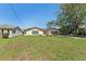 Single-story home featuring a spacious lawn, complemented by mature trees and a two-car garage at 3334 Pineview Dr, Holiday, FL 34691
