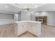 Bright, open kitchen island features stone counters, white cabinets, and wood floors at 3334 Pineview Dr, Holiday, FL 34691
