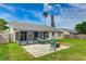 Expansive backyard with a screened lanai, patio, fire pit, swaying palm tree, and plenty of green space at 3410 5Th W Dr, Palmetto, FL 34221